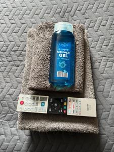 a bottle of water and a remote control on a bed at Autumn Leaves Guest House in Windermere