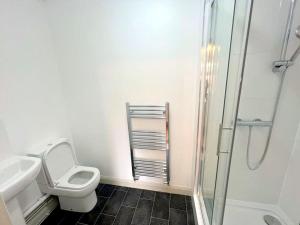 Cheam的住宿－Studio Apartments in Sutton (South London)，白色的浴室设有卫生间和淋浴。