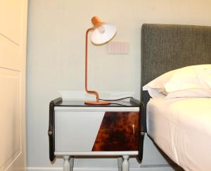 a table with a lamp on it next to a bed at Coco21 in Modena