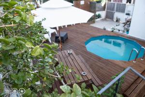 a wooden deck with a swimming pool on a balcony at The Shed Surf Lodge in Costa da Caparica