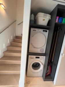 uma máquina de lavar e secar roupa numa lavandaria com escadas em Luxury Business Accommodation Geel em Geel