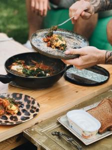 a group of people holding plates of food on a table at Sabay Sai Wooden Guesthouse in The National Park in Almaty