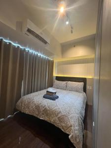 a bedroom with a bed with a white comforter at E & T Homecation 2 Bedroom at SMDC Air Residences in Manila