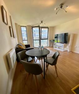 a living room with a table and chairs and a television at The Cube Side Apartments - One Bedroom With Balcony in Birmingham