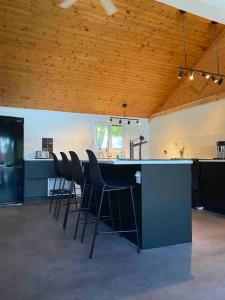 cocina con barra con sillas y barra en Willow Cabin- North Frontenac Lodge en Ompah