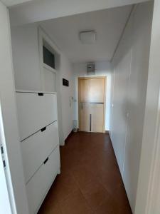 pusty korytarz z białymi szafkami i drzwiami w obiekcie Apartment City w Zagrzebiu
