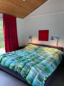 a bed with a colorful comforter in a bedroom at Willow Cabin- North Frontenac Lodge in Ompah