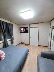 ein Schlafzimmer mit einem Bett und einem TV an der Wand in der Unterkunft A full private home in Seoul