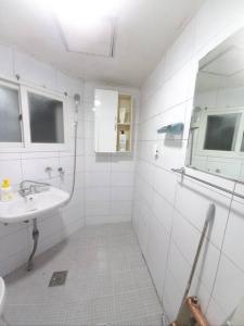 Baño blanco con lavabo y espejo en A full private home, en Seúl