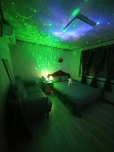 een slaapkamer met een groen plafond en een bed en een bank bij A full private home in Seoul