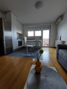 Apartment City في زغرب: غرفة معيشة مع مطبخ وطاولة مع مزهرية