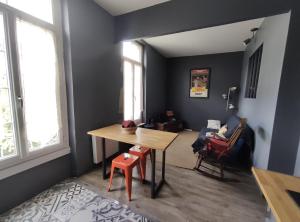 uma sala de jantar com uma mesa e cadeiras e um quarto com um sofá em Numéro 12, appartement douillet em Montauban