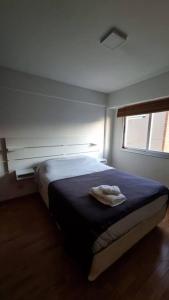 a bedroom with a bed with a towel on it at Departamento dos ambientes. in Castelar