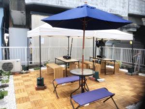 a table and chairs with an umbrella on a patio at 大阪西九条stay屋上BBQ可 in Osaka