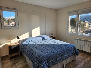- une chambre avec un lit et 2 fenêtres dans l'établissement Departamento muy luminoso, à San Carlos de Bariloche