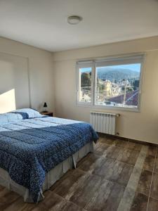 - une chambre avec un lit et une grande fenêtre dans l'établissement Departamento muy luminoso, à San Carlos de Bariloche