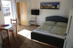 Schlafzimmer mit einem Bett, einem Tisch und einem Fenster in der Unterkunft FeWo-Roggenring-Leipzig in Leipzig
