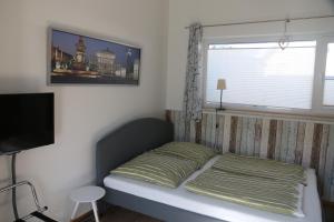 a small bedroom with a bed and a window at FeWo-Roggenring-Leipzig in Leipzig