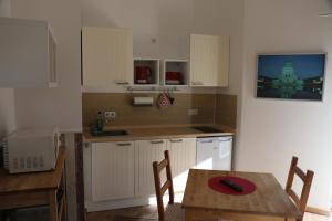 a kitchen with a table and a dining room at FeWo-Roggenring-Leipzig in Leipzig