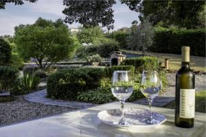 a bottle of wine and two glasses on a table at La Quercia casa vacanza Imperia in Imperia