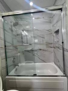 a bathroom with a glass shower with a tub at Fully Furnished Alluring Turn Key Luxury Oasis in Wellington