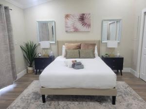 a bedroom with a large white bed with two night stands at Fully Furnished Alluring Turn Key Luxury Oasis in Wellington