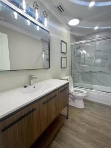 a bathroom with a sink and a toilet and a mirror at Fully Furnished Alluring Turn Key Luxury Oasis in Wellington