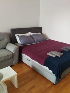 un letto con due cuscini e un divano in una camera di Apartment City a Zagabria