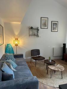 een woonkamer met een blauwe bank en een tafel bij Le Duplex Catherine - Metro - Gare - WIFI in Toulouse