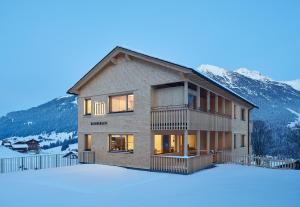een huis in de sneeuw voor een berg bij Tinn Naturchalet in Mittelberg
