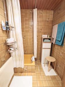 a small bathroom with a shower and a yellow bench at Ferienwohnung Fischer in Unterreichenbach
