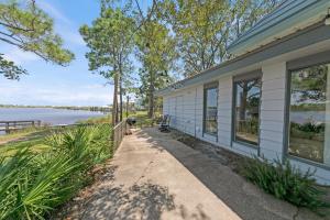 a house with a pathway next to the water at Sealake Cottage in Santa Rosa Beach