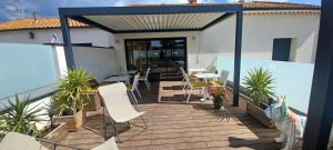 a deck with chairs and tables on a house at La maison du Potier in Valras-Plage