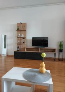 Apartment City في زغرب: غرفة معيشة مع طاولة بيضاء وتلفزيون