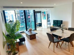 un soggiorno con tavolo, sedie e una grande finestra di Large 2B2B Near Southern Cross FreeParking GYM POOL a Melbourne
