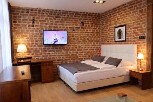 a bedroom with a bed and a brick wall at APARTAMENT PRZY RYNKU in Chełmno