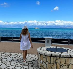 Una mujer con un vestido blanco caminando por el océano en Thalassa en Sidárion