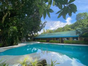 a swimming pool in front of a building at Camiguin Island Golden Sunset Beach Club in Mambajao
