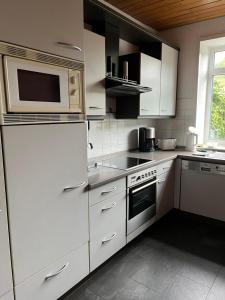 a kitchen with white cabinets and a microwave at Haus Hochwald in Hermeskeil