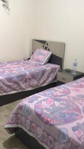 um quarto com duas camas e uma mesa de cabeceira em شاليه قرية قرطاج الساحل الشمالي em El Alamein
