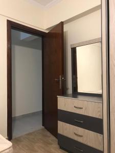 um quarto com uma cómoda com um espelho e uma porta em شاليه قرية قرطاج الساحل الشمالي em El Alamein