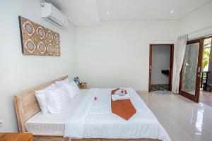 a bedroom with a large white bed in a room at Pondok Raamshanti Lembongan in Nusa Lembongan