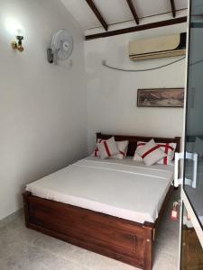 1 dormitorio con 1 cama con almohadas rojas y blancas en Viking Villa en Kalagedihena