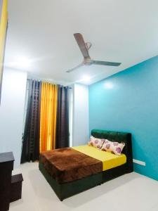 ein Schlafzimmer mit einem Bett und einer blauen Wand in der Unterkunft Marvelous Homestay SP Kedah in Sungai Petani