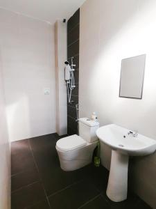 ein Badezimmer mit einem weißen WC und einem Waschbecken in der Unterkunft Marvelous Homestay SP Kedah in Sungai Petani