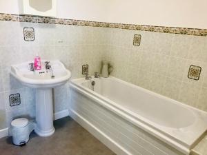 La salle de bains est pourvue d'un lavabo et d'une baignoire à côté d'un lavabo blanc. dans l'établissement Bransford Farm Fishery & B & B, à Bransford