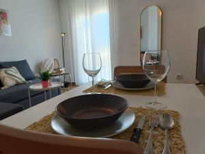 a table with a bowl and two wine glasses at Apartamento Happy Street in Socuéllamos