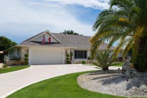 a house with a palm tree and a driveway at In the Heart of Naples, Suite with Lake & Pool in Naples