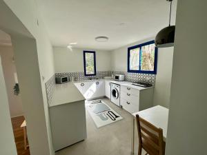 a kitchen with white counters and a dishwasher at Ein Hod - Artists Village in Ein Hod