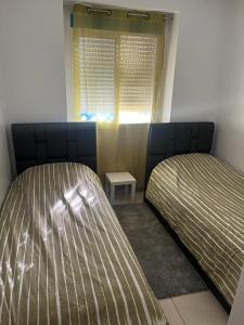 sypialnia z 2 łóżkami i oknem w obiekcie Charmant appart à 15 minutes de la plage et du centre ville M'DICQ, TETOUAN w mieście Mʼdik